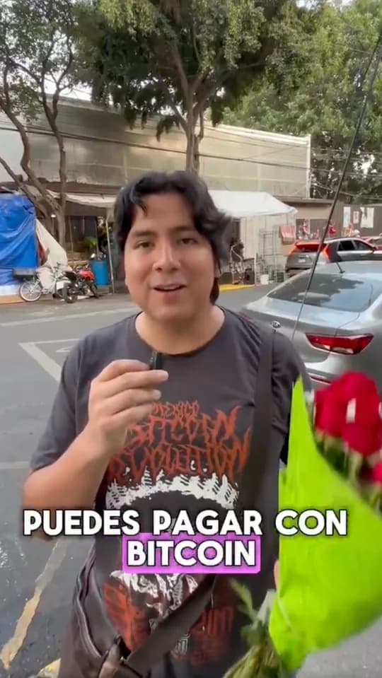 A man holds a bouquet of roses on the street, captioned You can pay with Bitcoin